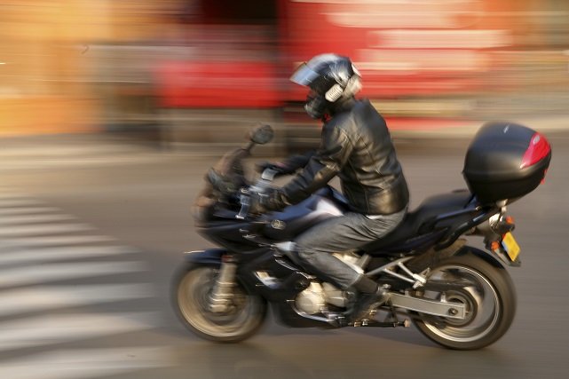 moto con baúl de moto circulando por la ciudad