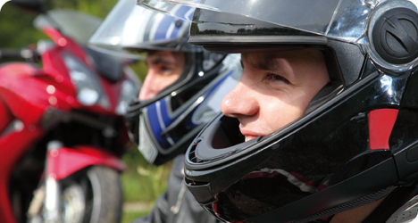 Hombre sonriendo con un casco de moto de color negro