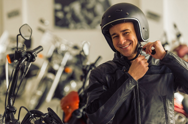 Hombre joven abrochándose casco