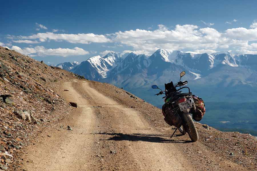 Moto con equipaje aparcada en un camino de tierra