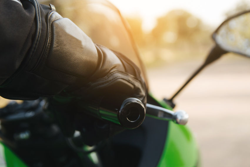 mano de un motorista con guante de protección agrrando el puño acelerador
