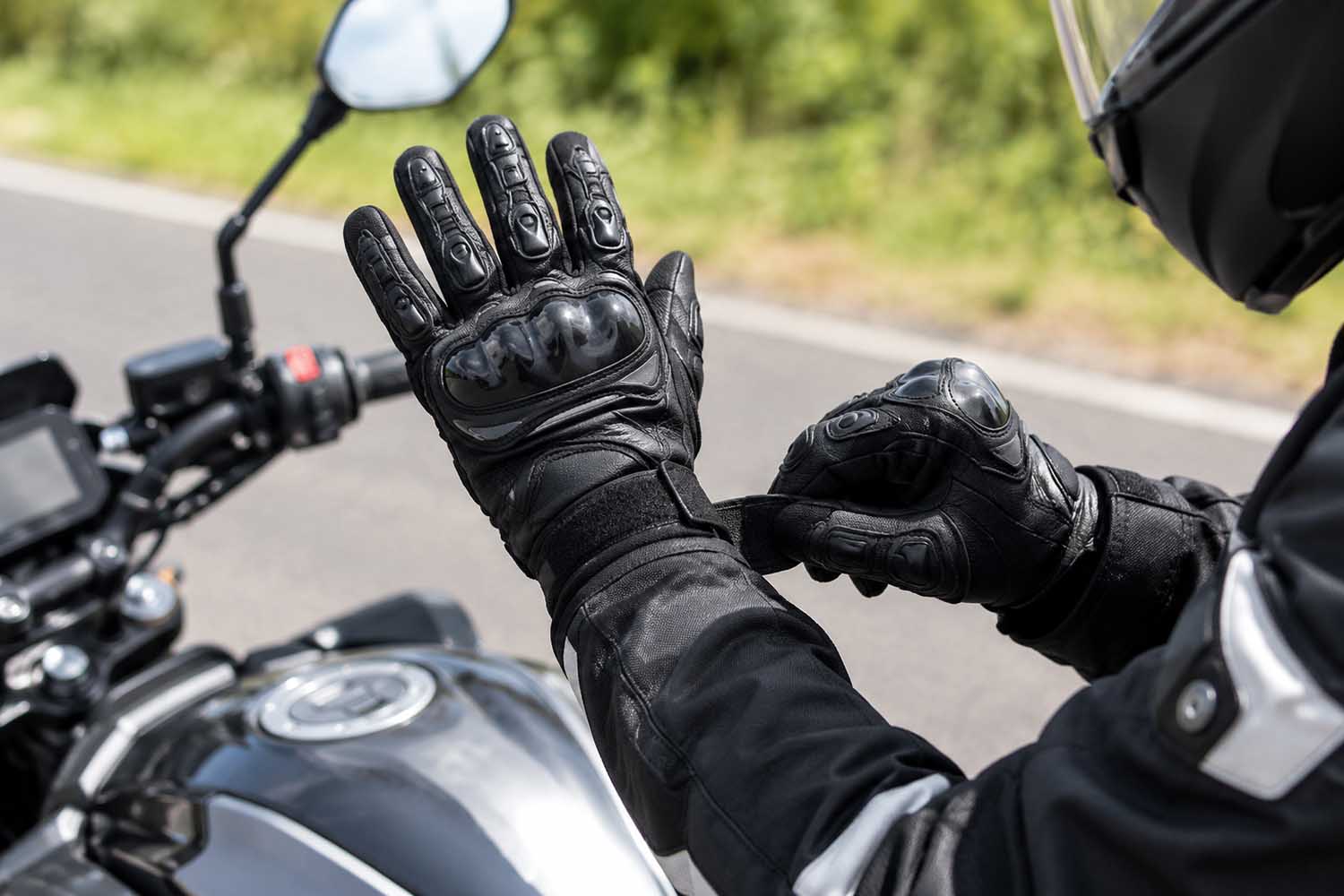 un motorista se ajustan un guante con protecciones
